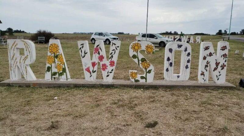 Con imágenes de flores y sembrados intervinieron las letras de acceso a Rawson